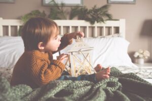 primo natale, bambino che gioca con una lanterna e luci