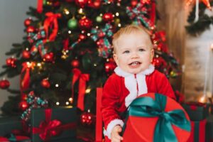 bambino con vestiti natalizi e pacco di natale